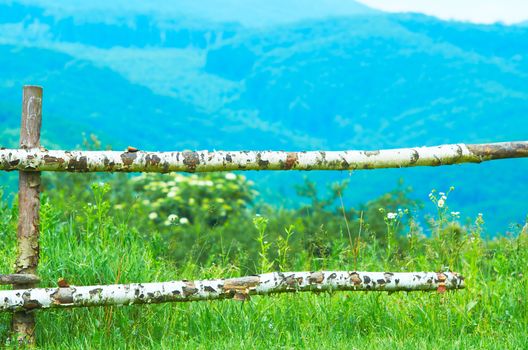 Wooden fence on pasture in the mountains