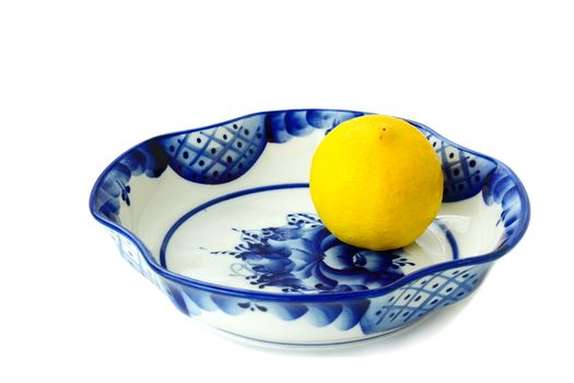 
White ceramic vase quadrangular for candies and fruit. It is painted with a blue-blue pattern in Gzhel style  and a lemon.

