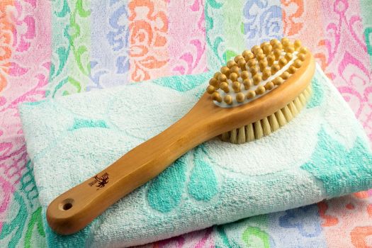 Wooden light brown brush with the long handle for body massage. Has wooden balls for massage and a rigid bristle for skin massage. Terry towel with an ornament.

