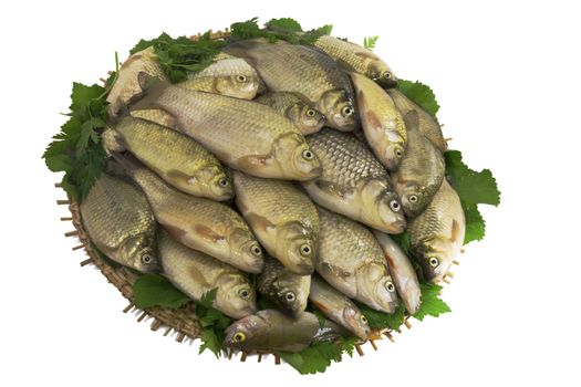 Carp and greens on a round dish. Presented on a white background.