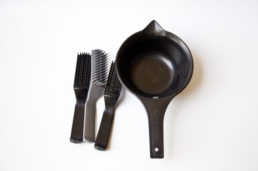 black comb and black bucket on white background