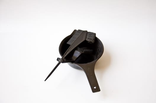 black comb and black bucket on white background