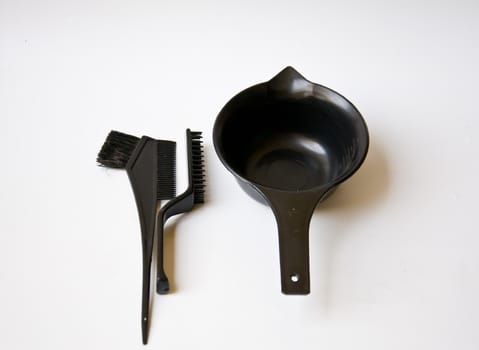 black comb and black bucket on white background