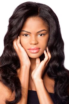 Beautiful African-American young woman with clean skin and hands in face and big wig hair extensions, makeup cosmetics haircare concept, on white.