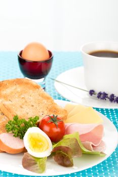 Breakfast with toast, cheese, sausage, ham, tomato, egg and cup of coffee.