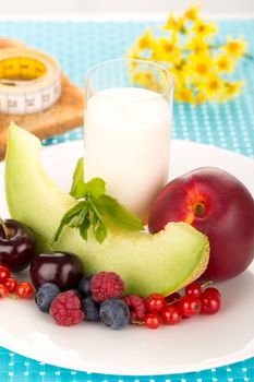 Healthy breakfast with a plate of fresh fruits, glass of milk.