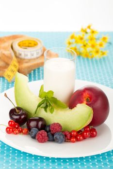 Healthy breakfast with a plate of fresh fruits, glass of milk.