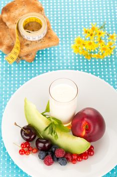 Healthy breakfast with a plate of fresh fruits, glass of milk.