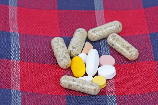 pill packet on red blanket background