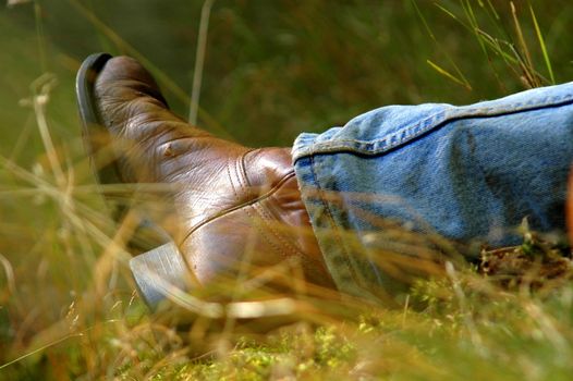 A Man's Boot As He Relaxes In A Meadow On A Sunny Day