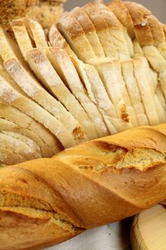 Bread roll and sliced bread arranged as a bread background.