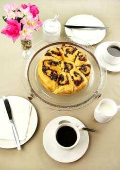 Delicious fresh baked chelsea bun with black coffee ready to serve.