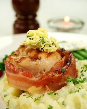 Chicken fillet mignon on parsley mashed potato with green beans.