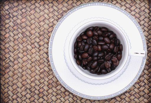 Coffee beans in a glass. Bamboo background