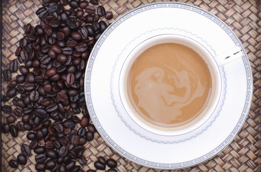 Coffee beans with coffee. Bamboo background