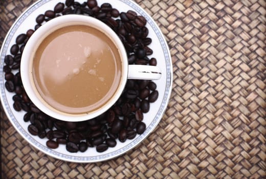 Coffee beans with coffee. Bamboo background