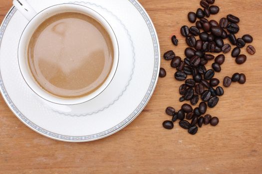 Coffee beans with coffee. wood background