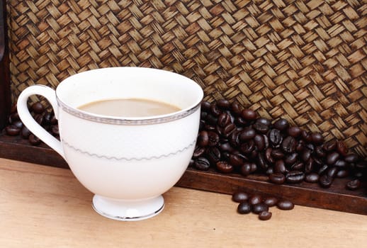 Coffee beans with coffee. Bamboo background