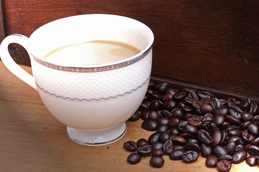 Coffee beans with coffee. wood background