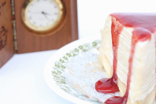 Strawberry cake on a white and clock background.