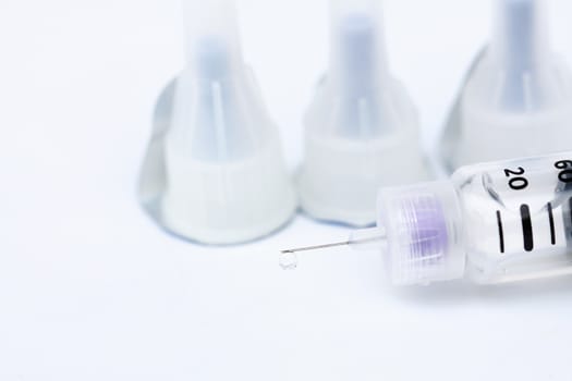 Droplets at the tip of the syringe on a white background