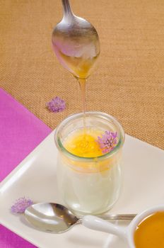 Pouring honey on a  fresh curd, a healthy breakfast