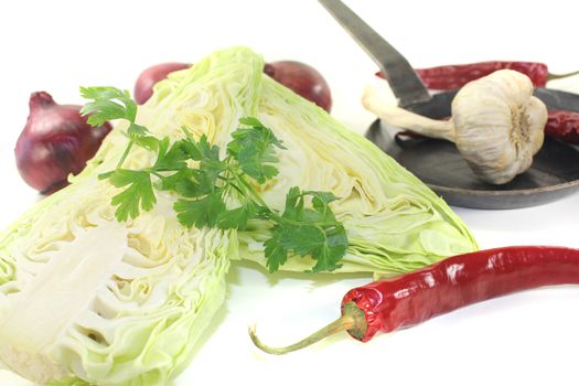 sweetheart cabbage with parsley and onions on a light background