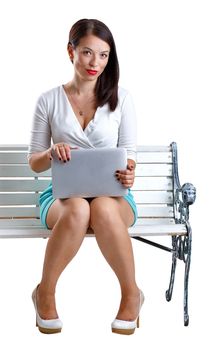 Girl with a laptop sitting on the bench isolated on white background