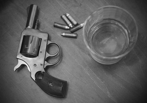 vintage pistol or gun with whiskey and bullets in black and white