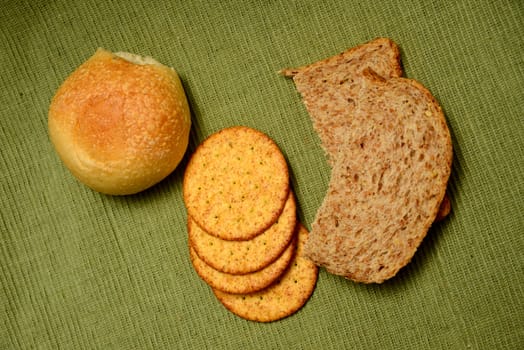 three different kinds of breads including rolls, crackers and whole grain loaf