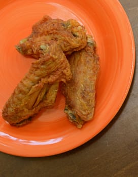 three fried chicken wings on a plate for a snack