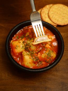 fork and cheese ravioli with rustic background