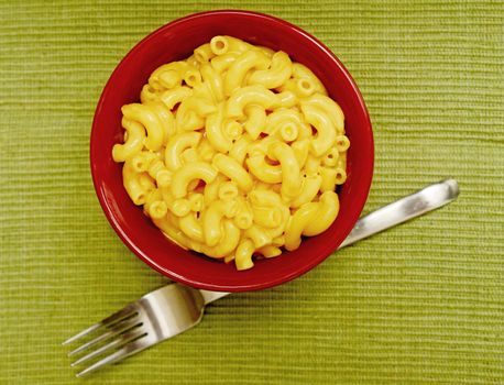 creamy and homemade macaroni and cheese in red bowl