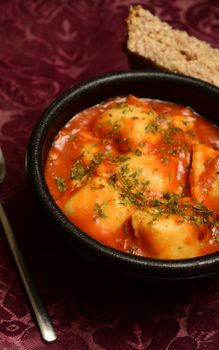 cheese ravioli with bread on burgundy background
