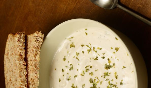 bowl of cream of chicken soup with bread on wood background