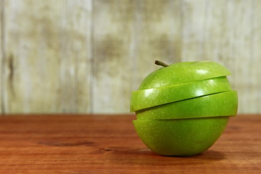 Green Apple Fruit Sliced Sitting on a Wooden Surface