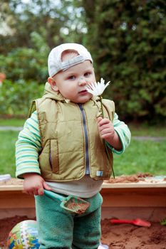 working boy playing in a sandbox with a car