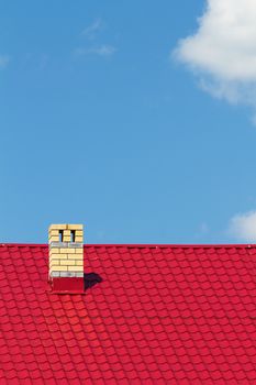 Red roof with chimney against the sky