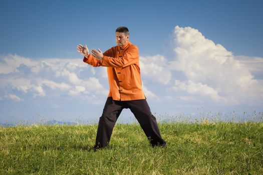 A man doing Qi-Gong in the green nature