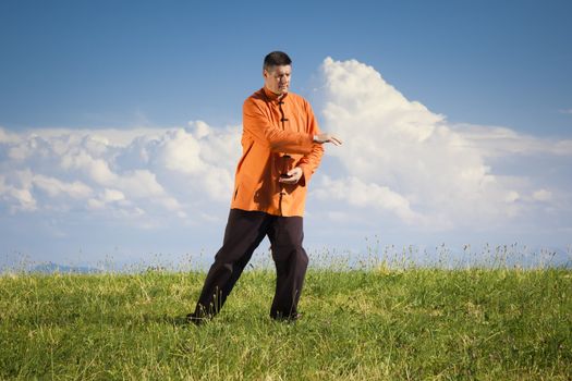 A man doing Qi-Gong in the green nature