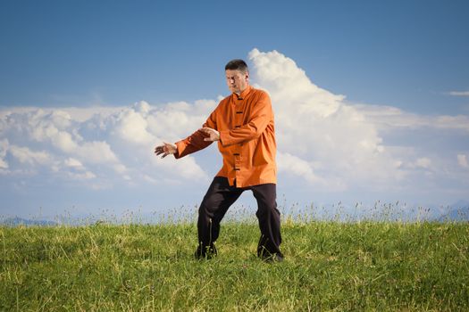 A man doing Qi-Gong in the green nature