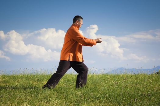 A man doing Qi-Gong in the green nature