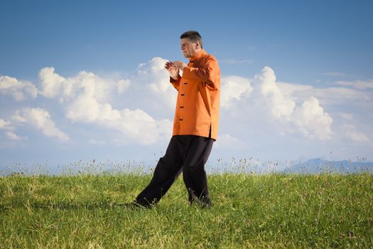 A man doing Qi-Gong in the green nature
