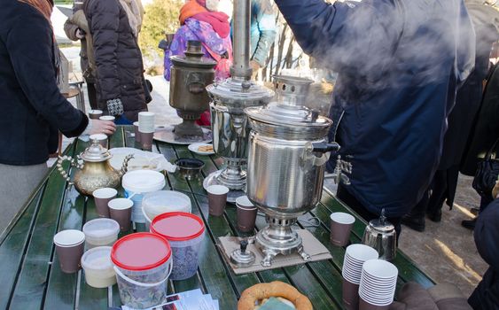 group of people make hot tea coffee with old retro equipment tool. cold winter day event. smoke rise.