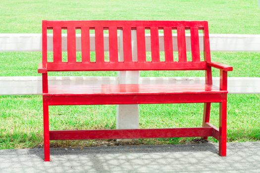 Red Bench Chair close to white Fence