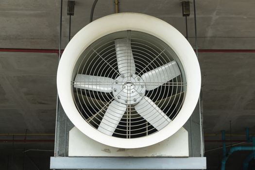 Industrial fan behind a metal grate.