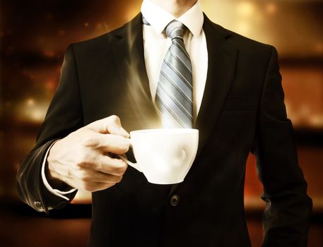 Business man holding a steaming cup of hot coffee
