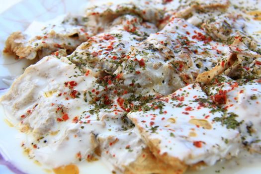 turkish manti manlama on plate with red pepper and mint on it