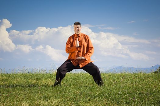 A man doing Qi-Gong in the green nature