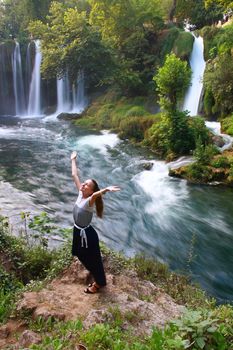 girl in waterfall enjoying life with mountain and waterfall view